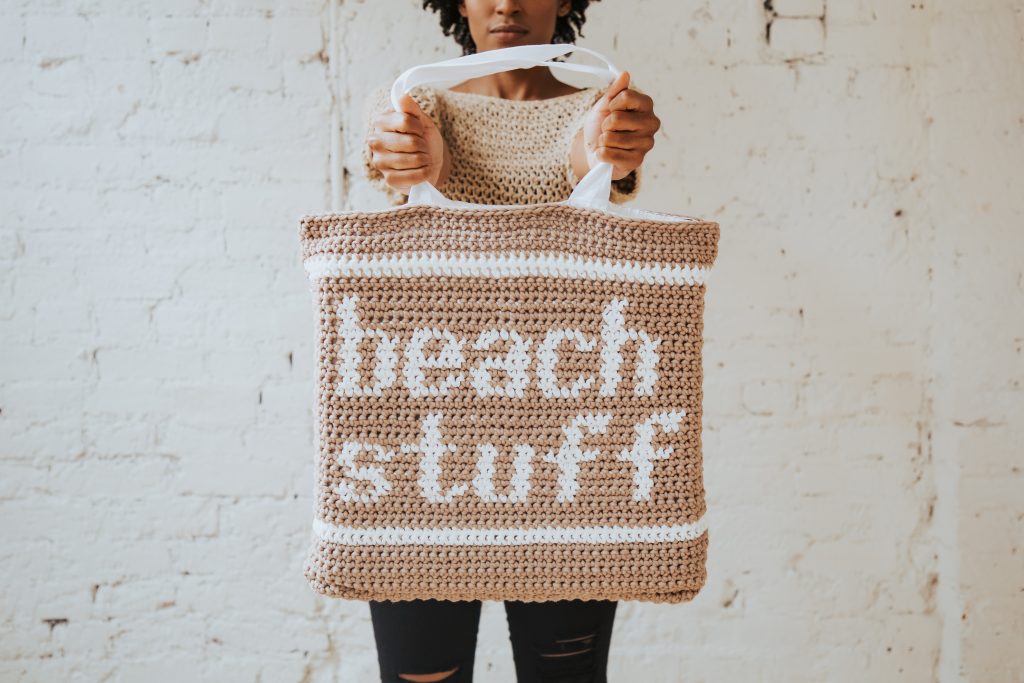Try the new Beach Stuff Tote, a summer essential! This crochet bag uses the tapestry crochet technique to create graphic and fun text. Finish your bag by sewing in a canvas tote bag from JOANN for easy straps that won't stretch! Free pattern on TLYCBlog.com or get a printable version from TLYarnCrafts.com.