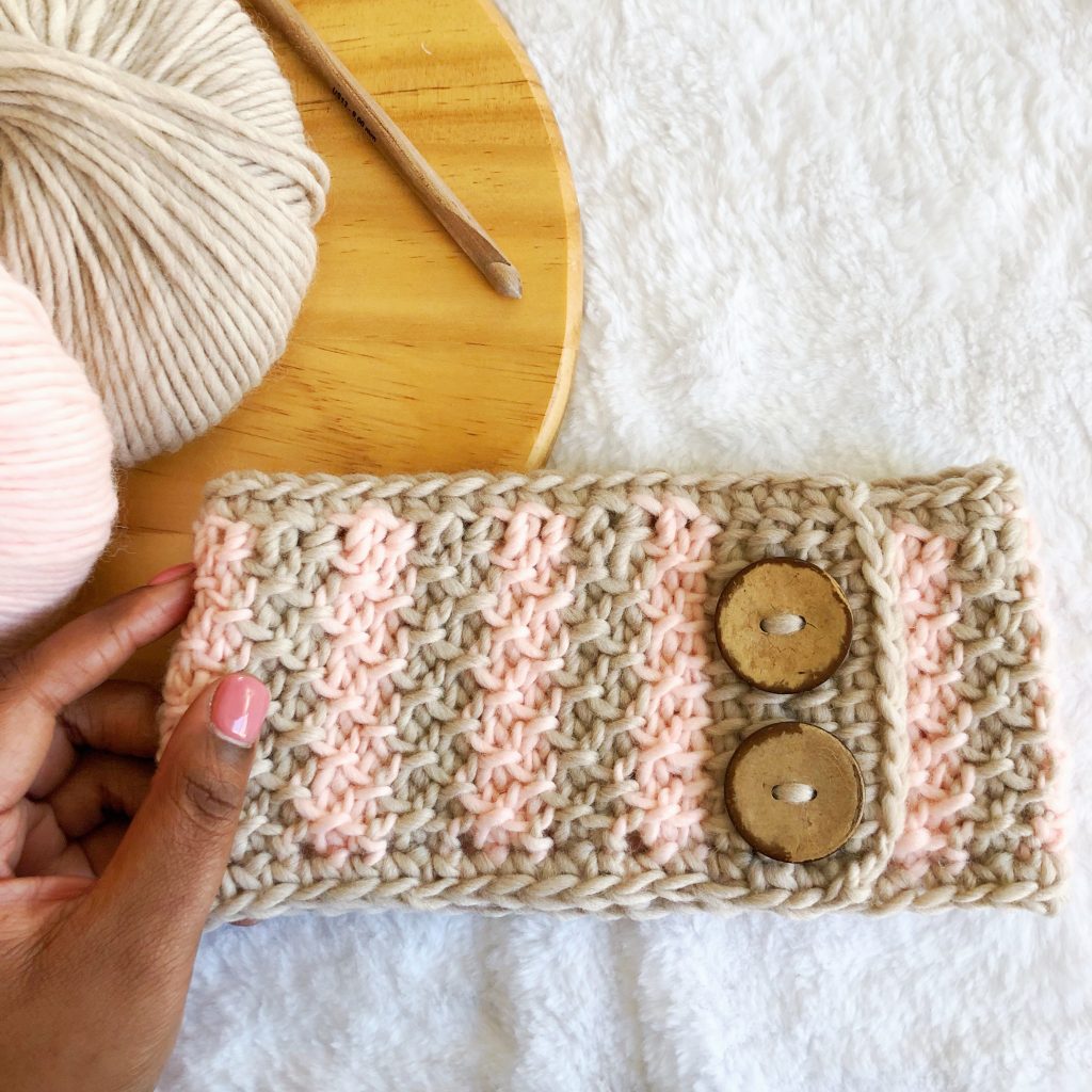 Take your Tunisian crochet skills to the next level! Try the beginner friendly Honeycomb Tunisian Ear Warmer, a cozy crochet headband with faux button closure. Pattern includes a step-by-step video tutorial. Use your stash yarn and make this project in worsted, aran, or bulky weight yarn. | TLYCBlog.com