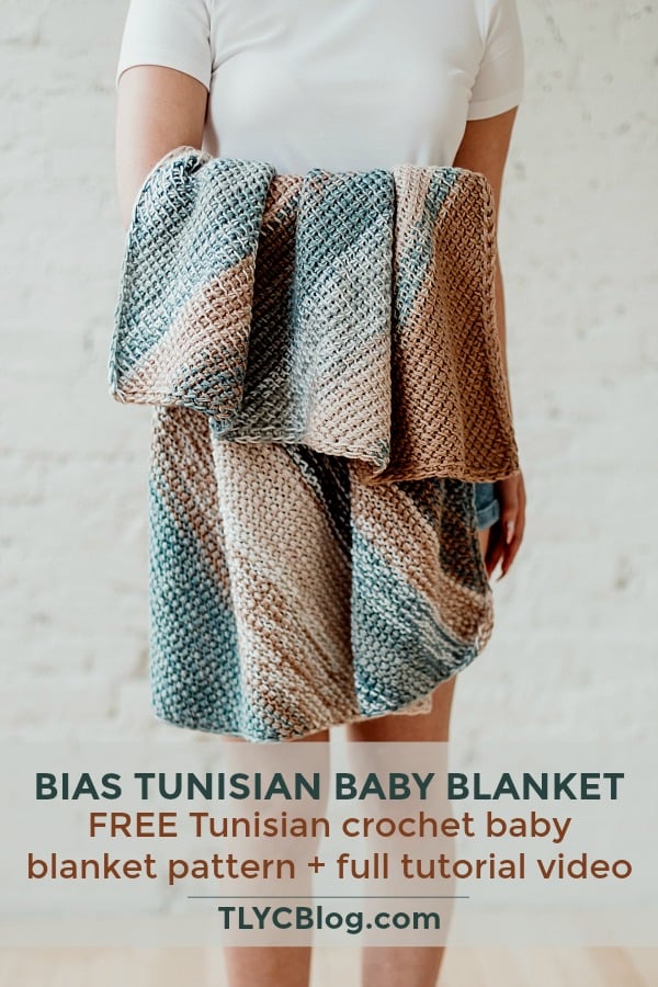 Make the fun and fast Bias Tunisian Baby Blanket, a FREE beginner-friendly corner-to-corner baby blanket from TLYCBlog in collaboration with JOANN stores. Pick your favorite color-changing cake yarn to achieve the unique marled look of this blanket. The FREE pattern available on the blog also includes a ste-by-step tutorial video and is perfect for those new to Tunisian crochet. | TLYCBlog.com