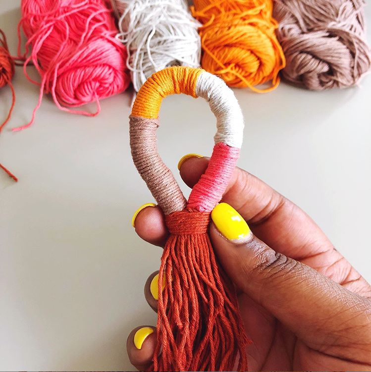 Try this quick and fun tutorial for yarn wrapped tassels, also called keyhole tassels. Grab some leftover yarn scraps from your stash and make these fun hanging tassels to adorn your keychain or handbag, add to a friendship bracelet, or even make into earrings! | TLYCBlog.com