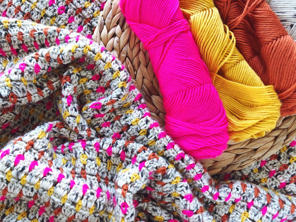 Good Vibes Throw, a FREE crochet pattern for a colorful, bold, and modern throw blanket. Free pattern includes a video tutorial and step-by-step instructions. Easy for beginner crocheters! #handmadewithjoann | TLYCBlog.com