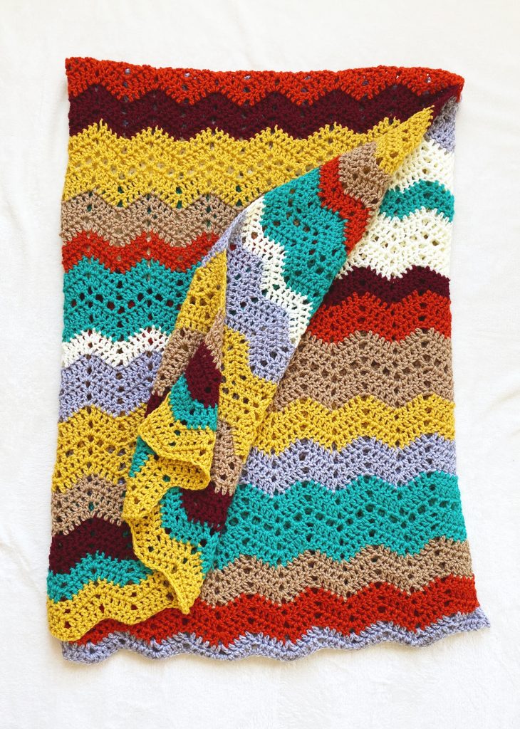 Free Crochet Blanket Pattern - Autumn Skies Afghan. Colorful crochet afghan made with worsted weight acrylic yarn in seven colors. Lion Brand Basic Stitch Premium. Easy crochet throw blanket pattern for beginners. Free pattern. | TLYCBlog.com