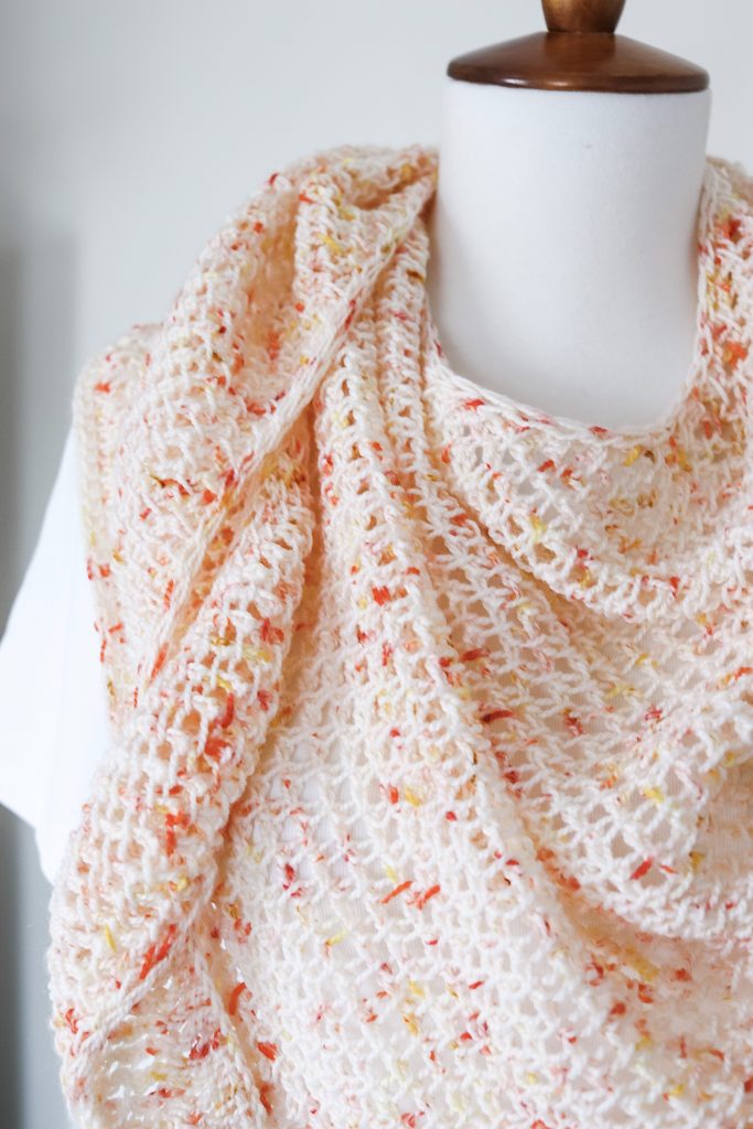Make the Party Punch Shawl, a Tunisian crochet triangle wrap made with one skein of fingering weight yarn. Beginner friendly with tutorial video, fun summer wrap crochet pattern. | TLYCBlog.com