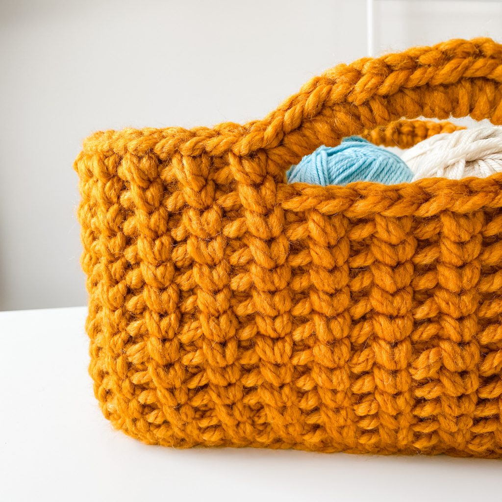 Make the Jessie Stash Basket, a chunky crochet basket, using the free pattern and included tutorial video. This easy, modern crochet storage basket is perfect for holding your projects and for gift giving. Make this large rectangle crochet yarn storage basket today! | TLYCBlog.com