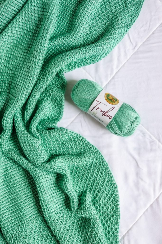 Free crochet baby blanket pattern for beginners. Easy Tunisian crochet baby blanket pattern made with bamboo yarn. Basic Tunisian crochet blanket pattern with helpful videos. Elmore blanket - basic Tunisian crochet blanket with honeycomb edge border. | TLYCBlog.com