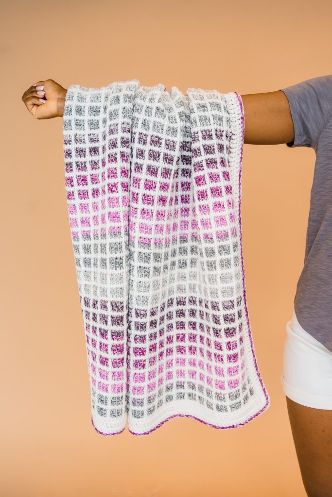 Finally ready to learn Tunisian crochet? Try the Mulberry Afghan, a FREE Tunisian crochet block stitch baby blanket that uses color changing cake yarn! | TLYCBlog.com