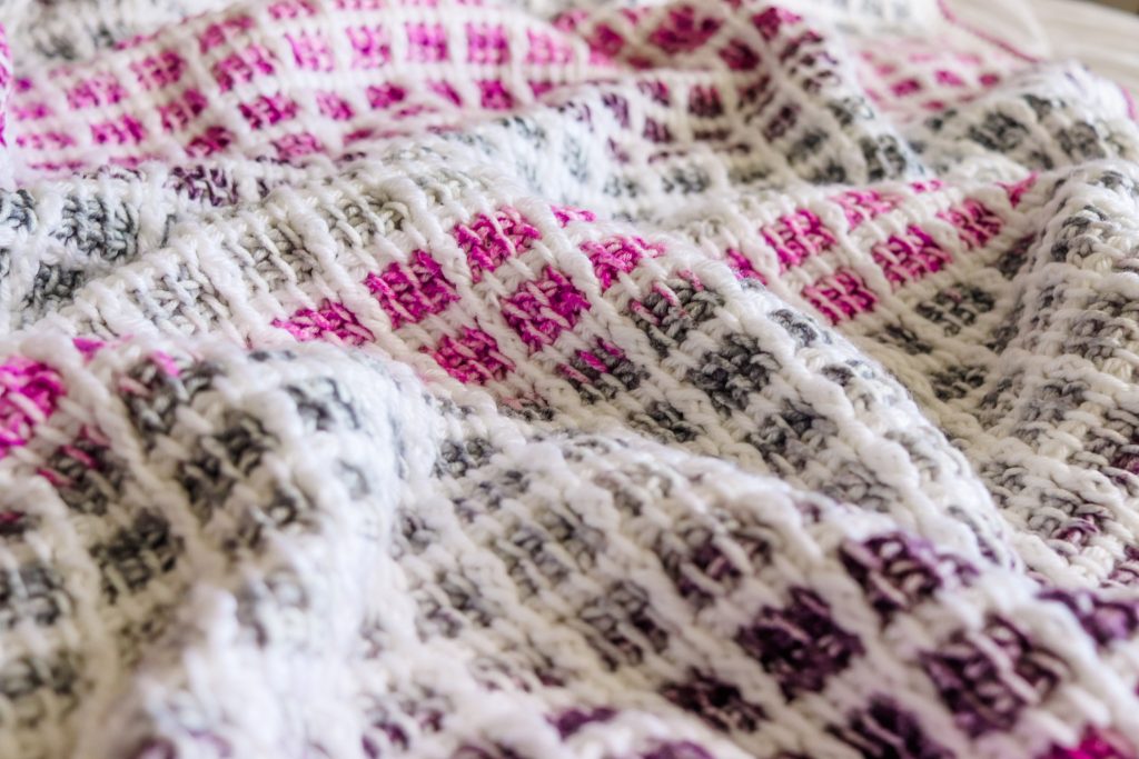 Finally ready to learn Tunisian crochet? Try the Mulberry Afghan, a FREE Tunisian crochet block stitch baby blanket that uses color changing cake yarn! | TLYCBlog.com