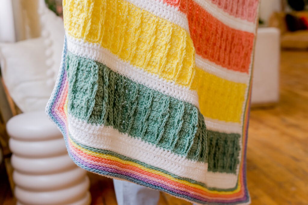 Crochet faux cable spring pastel baby blanket - free crochet pattern. Jacobs ladder dupe pastel rainbow crochet pattern - video tutorial. | TLYCBlog.com