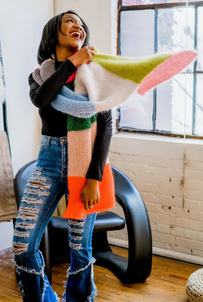 Model wearing the Bestie Scarf by TL Yarn Crafts, a large color-blocked crochet scarf made with yarn held double with mohair for a soft, airy texture.