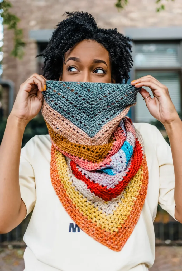 Model wearing the Ginger Cowl by TL Yarn Crafts, a colorful bandana-style crochet cowl.