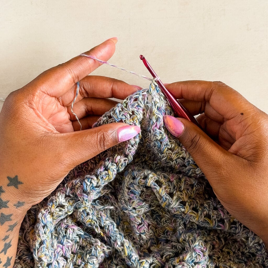 Crocheter holding the working yarn with a single wrap around the index finger.