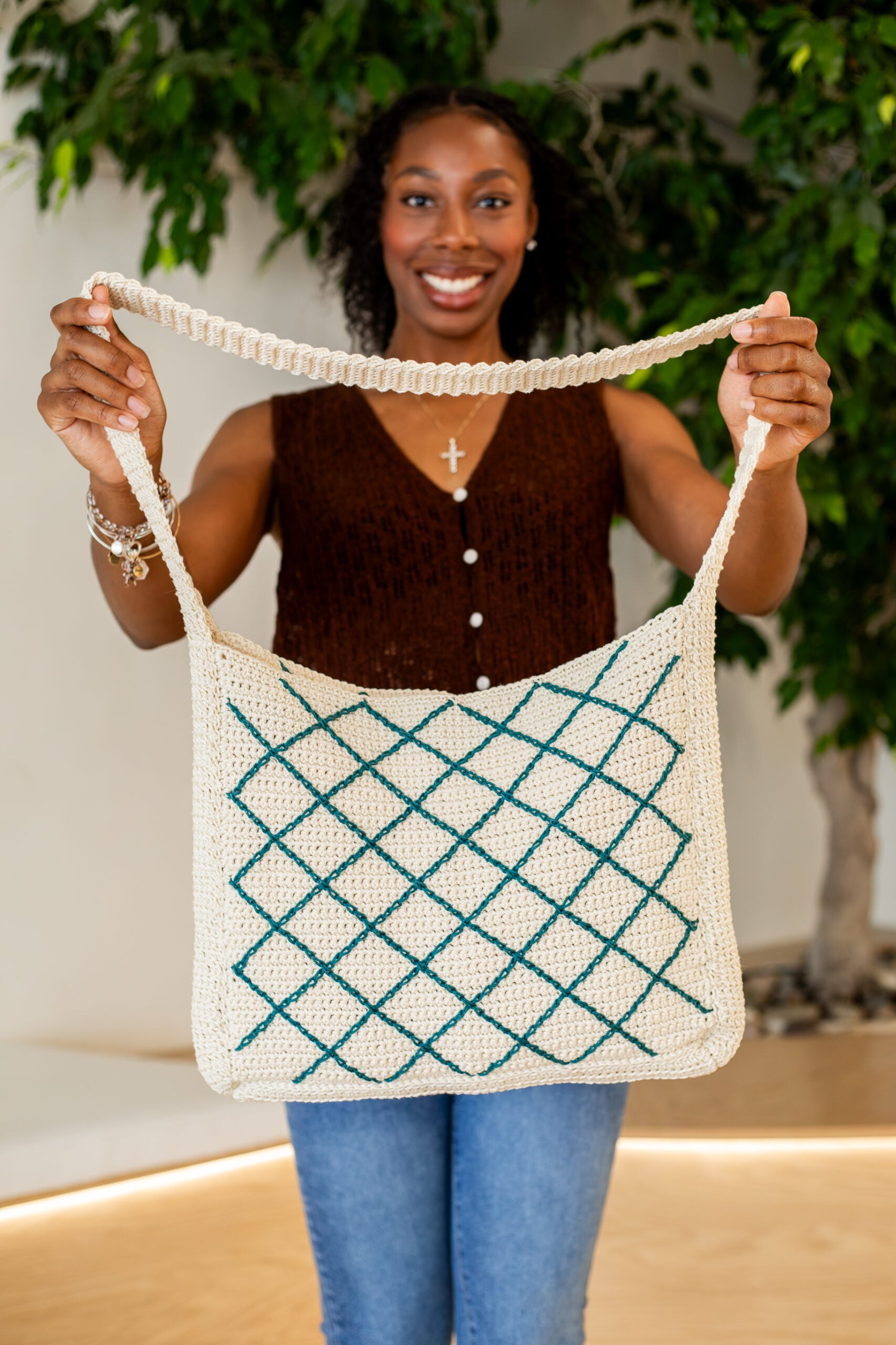Woman presenting a crochet crossbody tote bag - free crochet pattern, the October Tote Bag