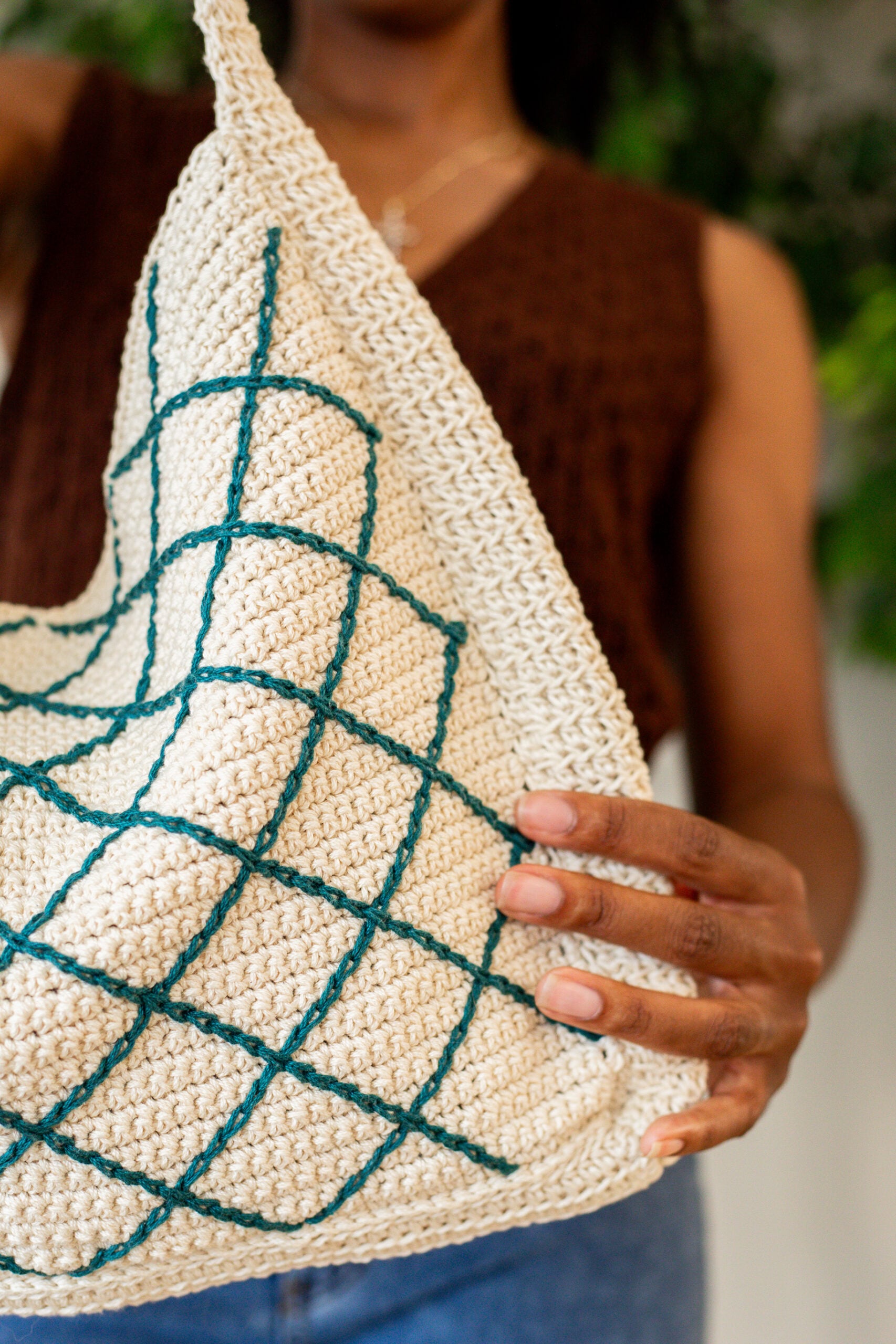 Closeup of a woman holding a crochet crossbody tote bag - free crochet pattern, the October Tote Bag
