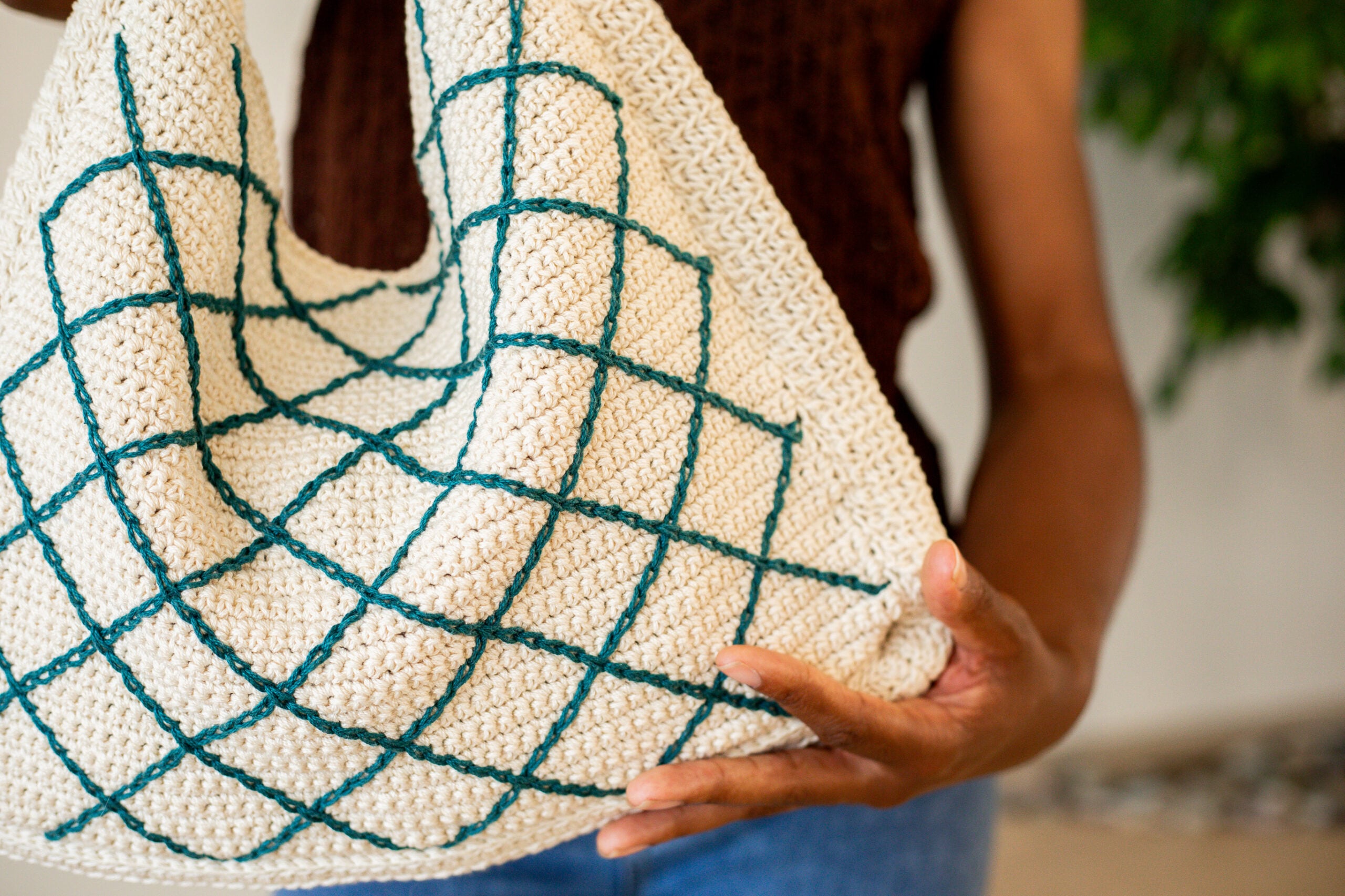 Woman holding a crochet crossbody tote bag - free crochet pattern, the October Tote Bag