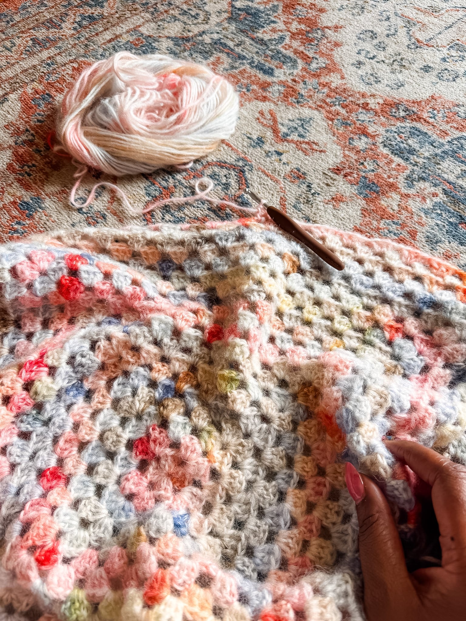 Close up of a pink and blue granny square cardigan - free crochet pattern