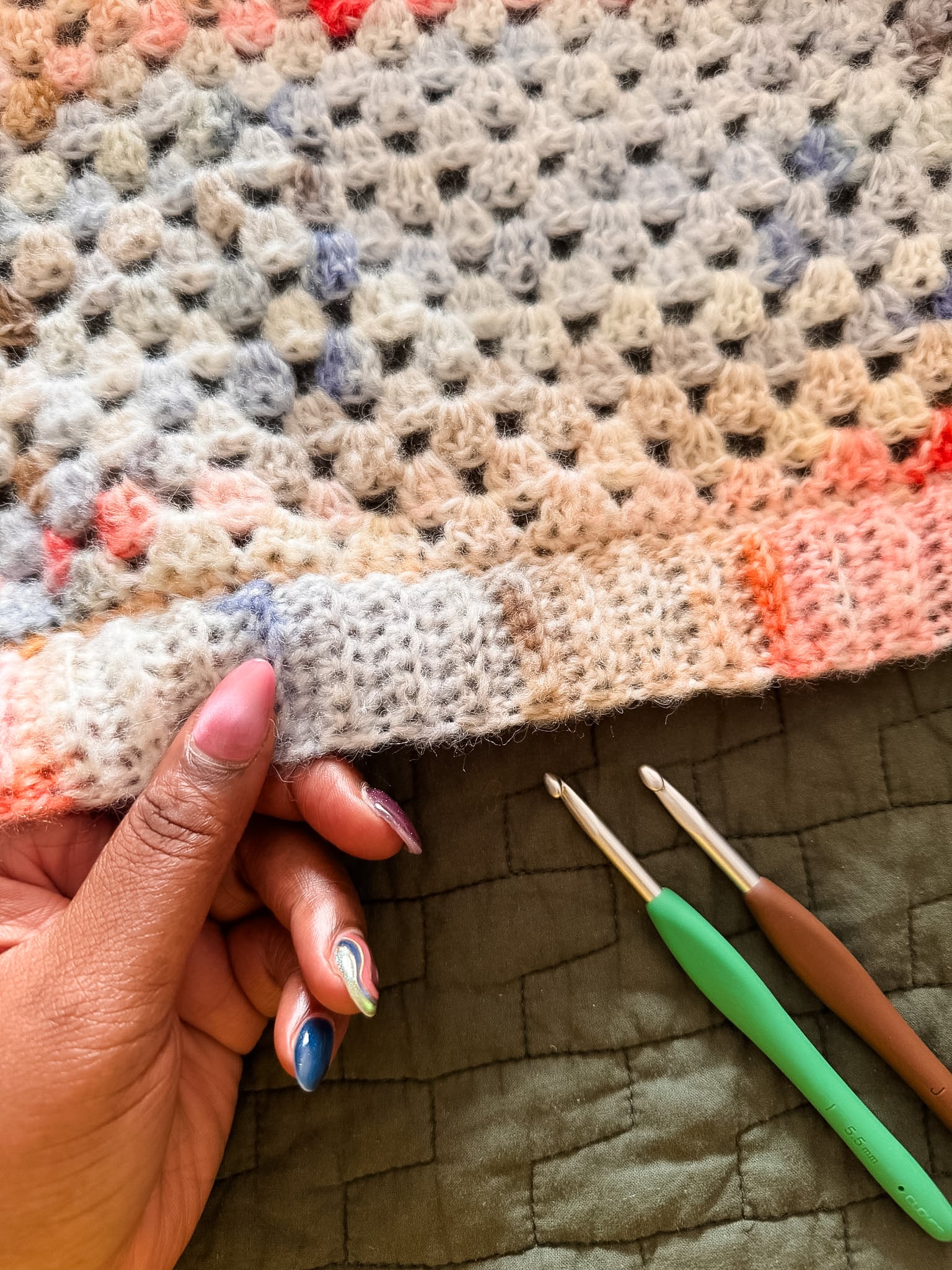 Closeup of ribbing on a pink and blue granny square cardigan - free crochet pattern